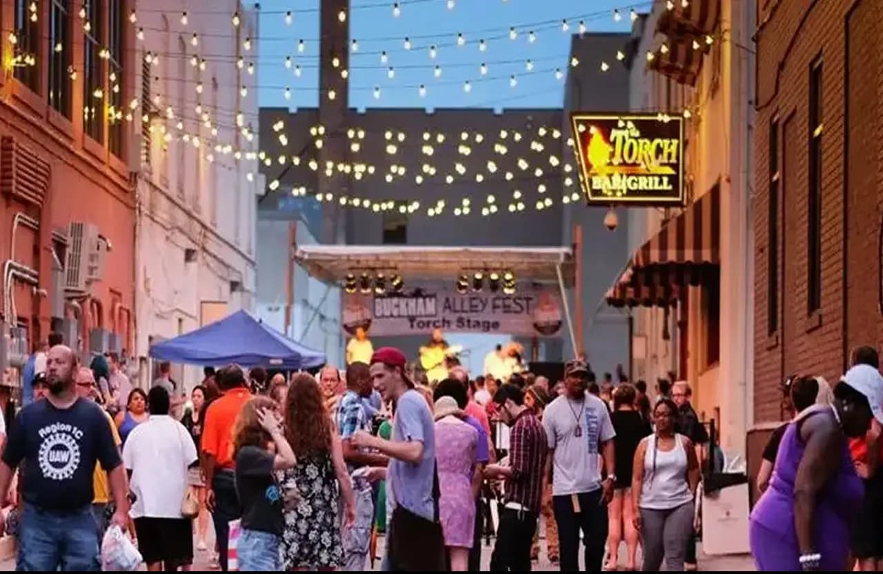 Buckham Alley crowd at night with string lights outside Torch