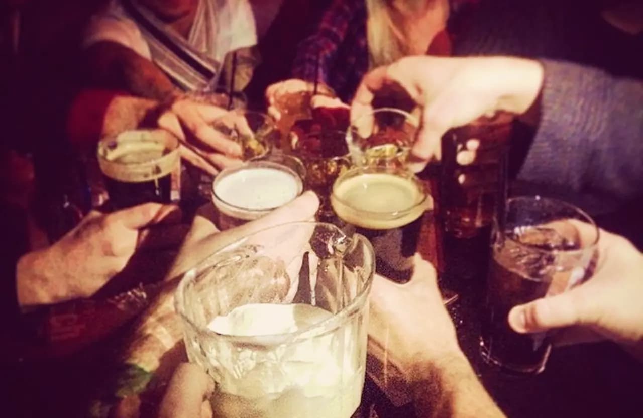 Friends raising glasses for a toast inside Torch Bar & Grill
