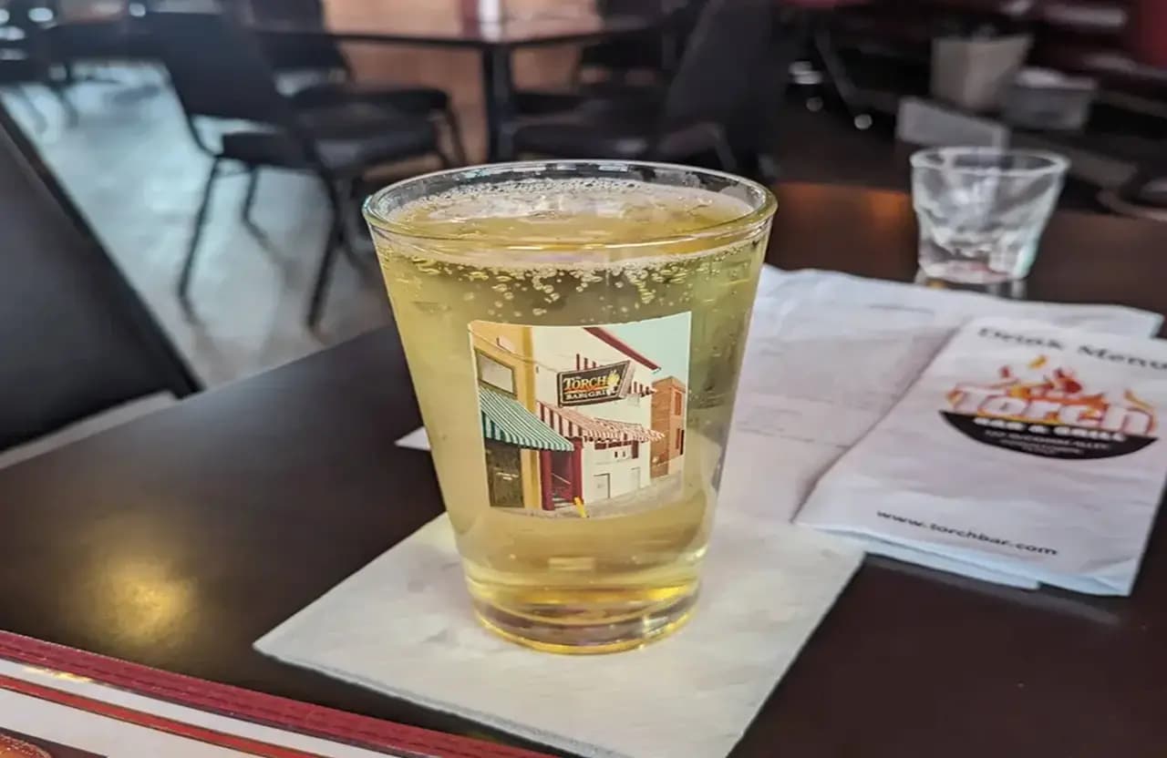 Drink served on the Torch Bar counter with bar menu in the background